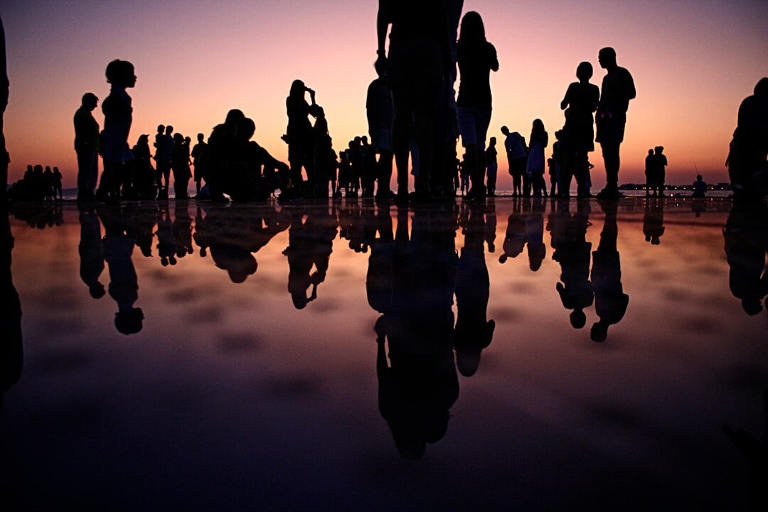 Silhouettes of a crowd of people at a dusk event